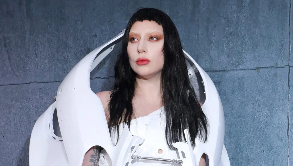 Lady Gaga posing in a glamorous silver outfit at a movie premiere, smiling confidently — related to Lady Gaga net worth and her successful career in music and film.