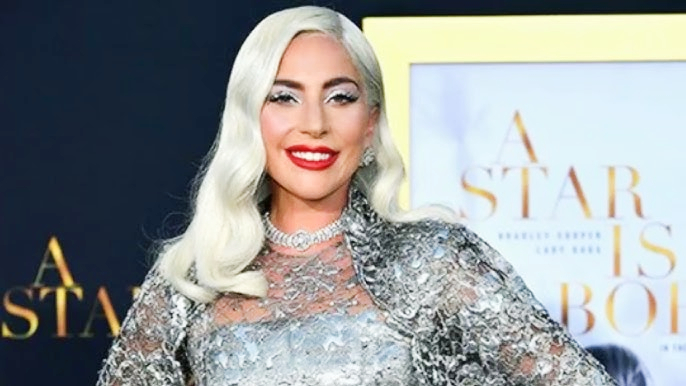 Lady Gaga wearing an avant-garde white futuristic outfit with dark hair and bold makeup, showcasing her unique fashion style — associated with Lady Gaga net worth and global stardom.