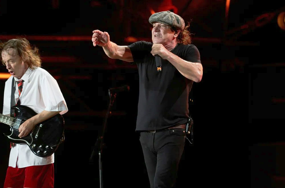 Brian Johnson belts out AC/DC hits on stage with Angus Young during the 2025 Power Up Tour, showcasing his legendary raspy vocals and high-energy performance.