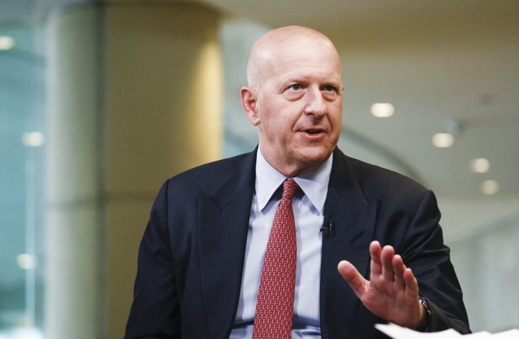 A business executive in a suit speaking during an interview, illustrating themes of corporate leadership and insights often discussed in David Solomon–related business topics.”