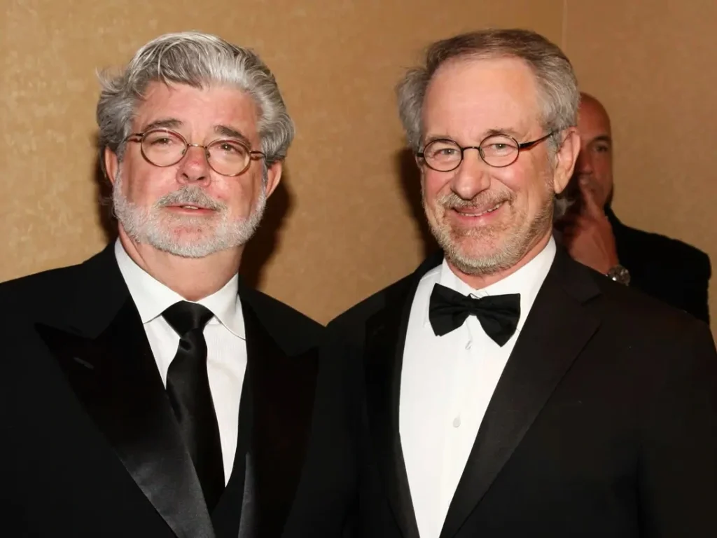 Two legendary Hollywood filmmakers wearing tuxedos at a formal industry event