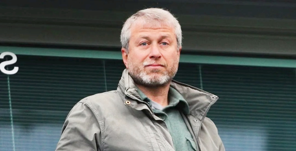 A man with short gray hair and a beard wearing a green jacket, standing outdoors, used for an article about Roman Abramovich Net Worth.